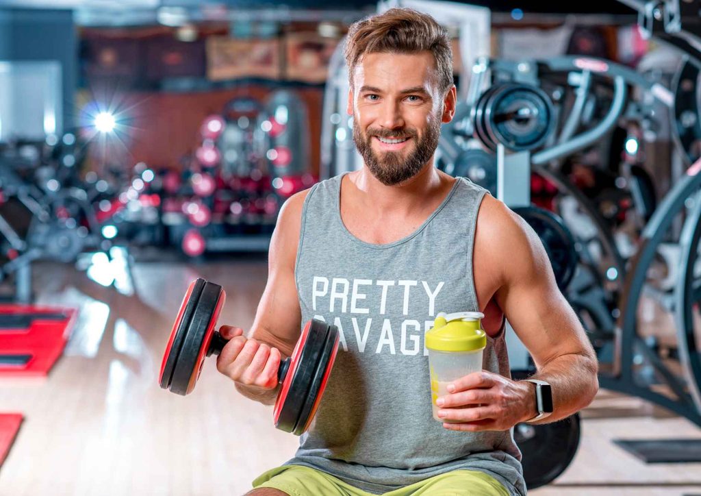 What Is a Sports Nutritionist? 19 A man sits on a gym bench, holding a dumbbell in one hand, focused on his workout routine.