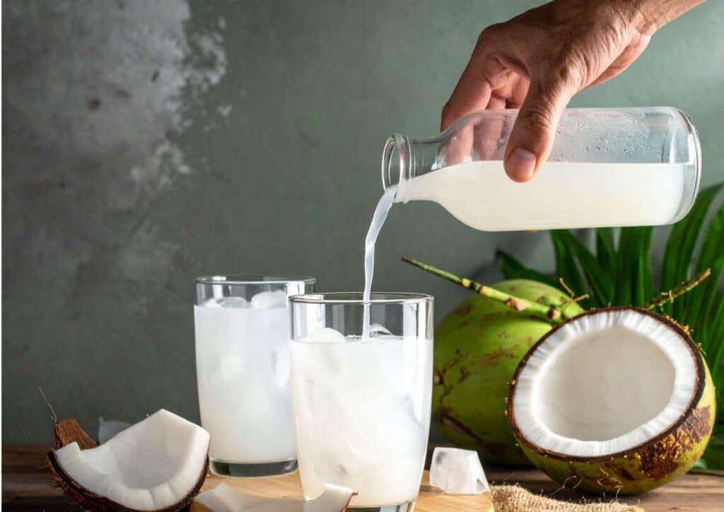 Is Coconut Water Good for Weight Loss? 7 Coconut water served in a clear glass with a straw, showcasing its refreshing and natural appearance.