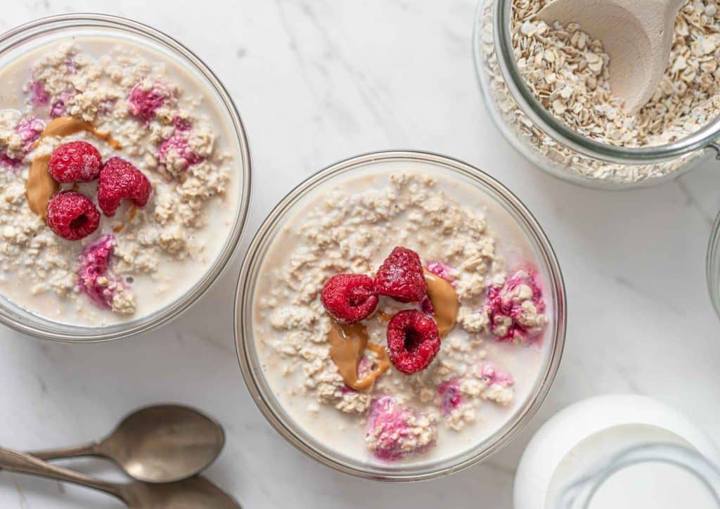 Are Oats Good for Weight Loss? 10 A bowl of oatmeal topped with fresh raspberries and a dollop of peanut butter, showcasing a nutritious breakfast option.