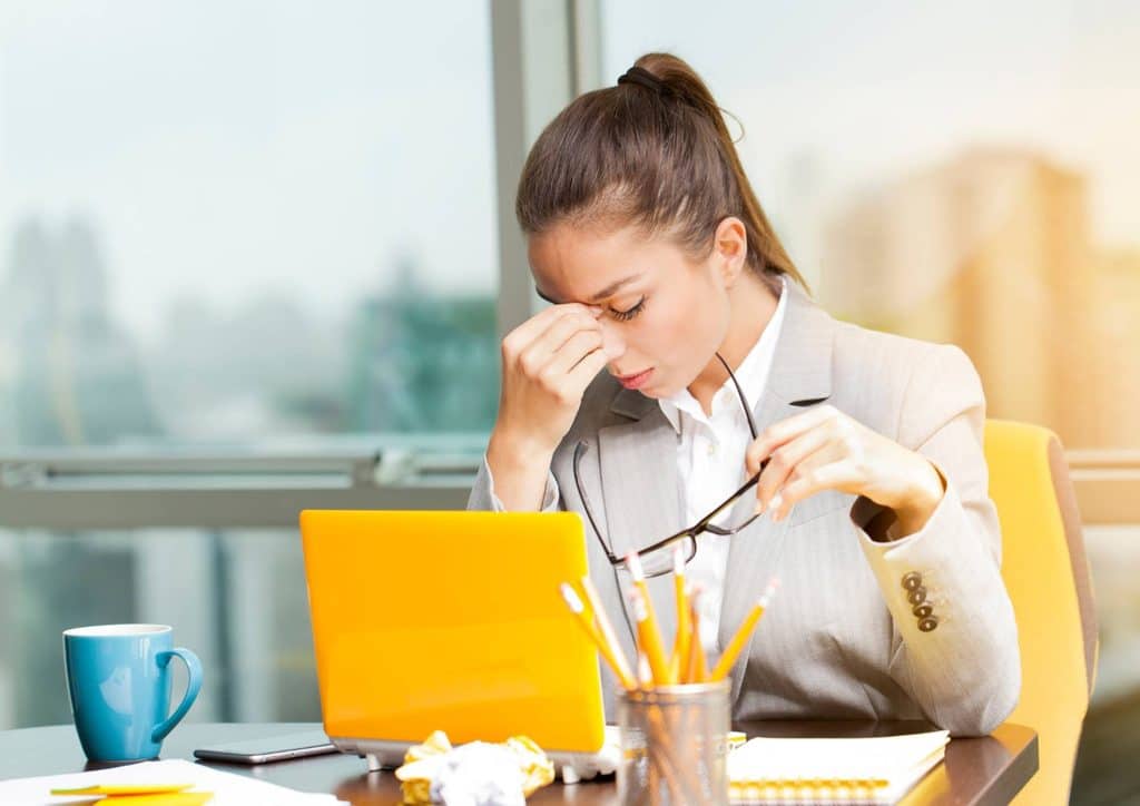 Why Am I Not Losing Weight? 8 Reasons a Nutritionist Sees Every Week 23 A woman in a business suit sits at a desk, focused on her laptop, conveying a professional work environment.