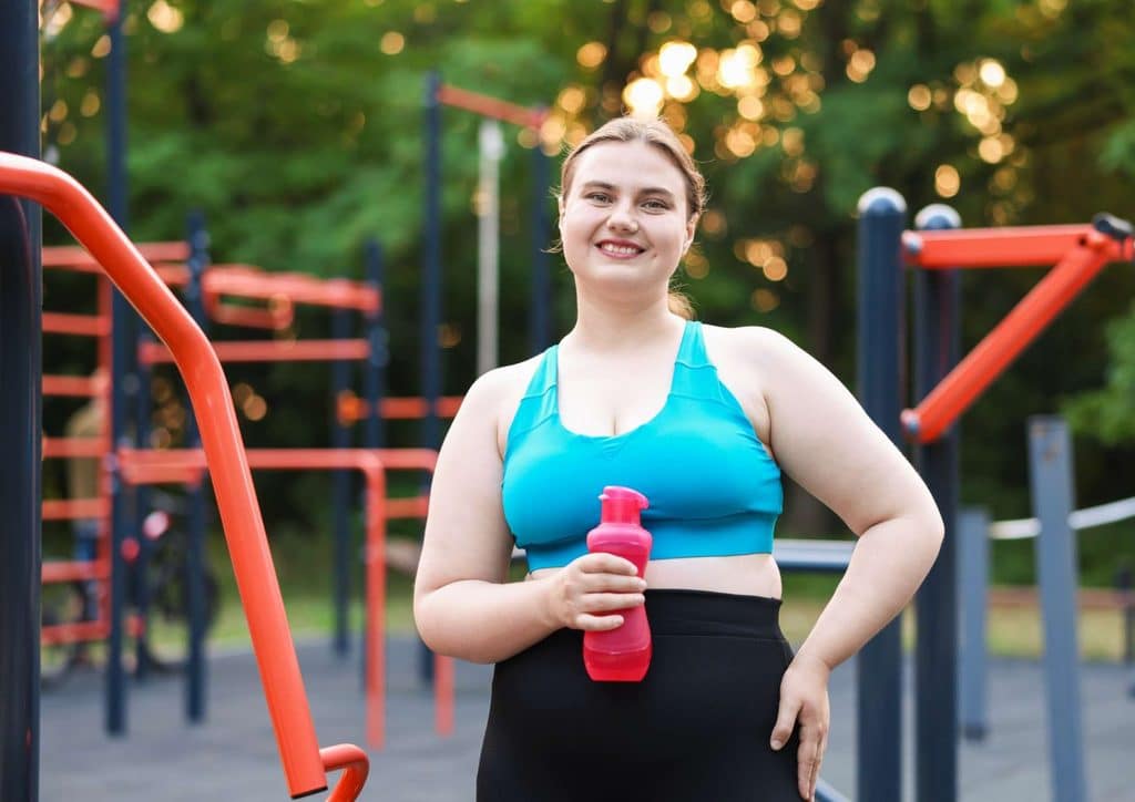 Not Losing Weight in a Calorie Deficit? Here's Why 19 A woman in a sports bra and leggings holds a water bottle, ready for a workout or exercise session.