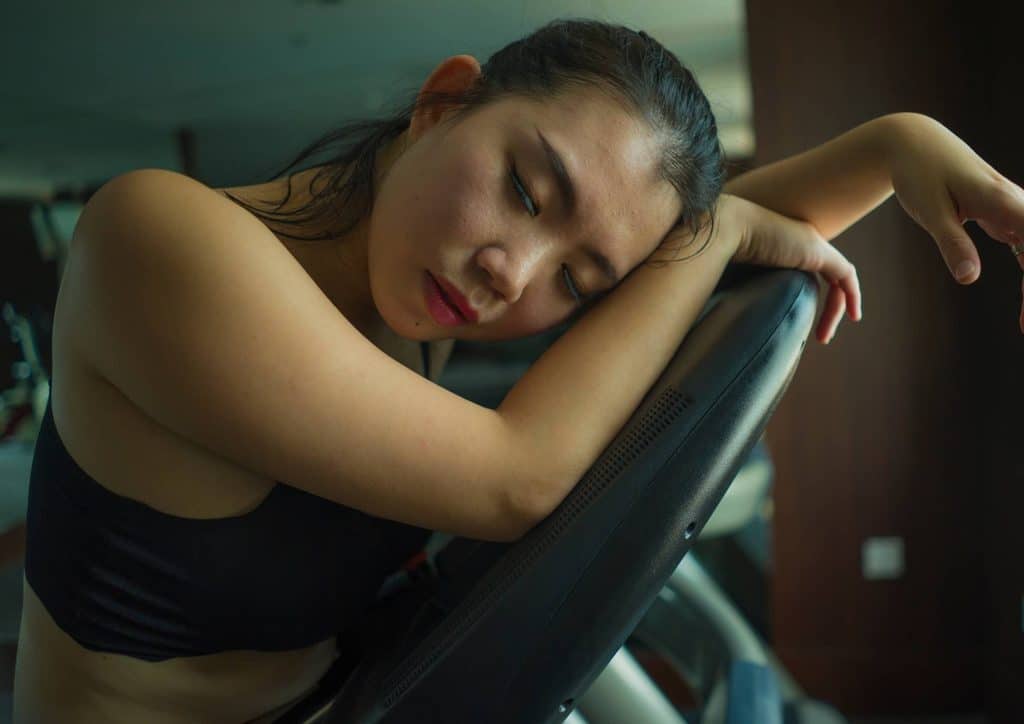 How to Lose Weight Without Exercise 4 A woman rests her head on a chair, appearing relaxed and contemplative in a serene environment.