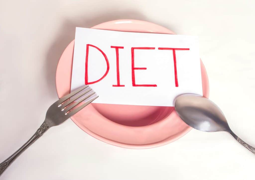 How to Lose Weight Without Exercise 10 A pink plate featuring a fork and spoon, representing a healthy eating theme.