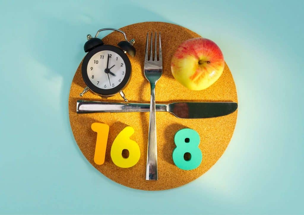 Intermittent Fasting for Weight Loss: Does It Actually Work? 13 A cork board displaying a fork, knife, and a red apple arranged neatly.