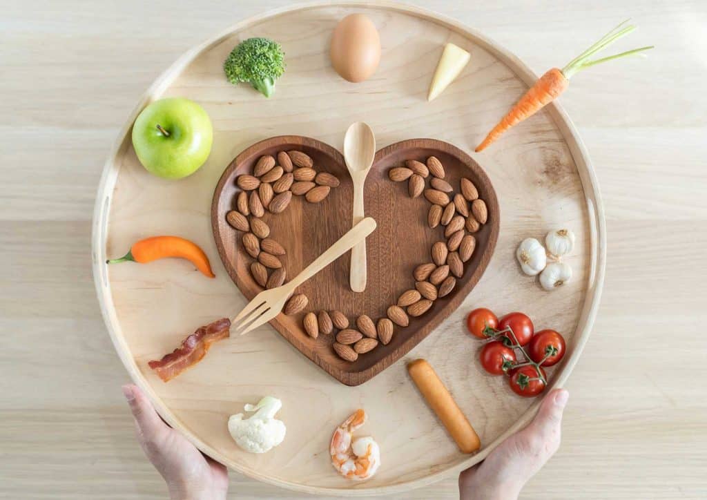 How to Speed Up Your Metabolism (What Actually Works) 26 A person holding a plate of food in one hand and a fork in the other, ready to eat.