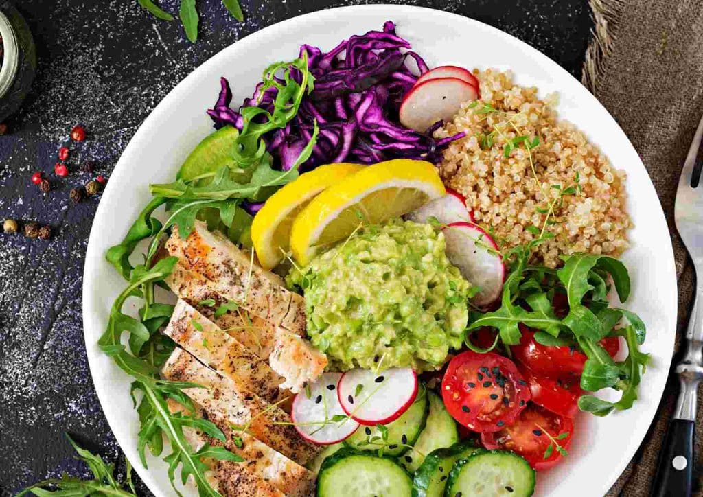 Natural Alternatives to Ozempic for Weight Loss 15 A bowl filled with chicken, avocado, cucumber, tomatoes, and assorted vegetables, showcasing a colourful and healthy meal.