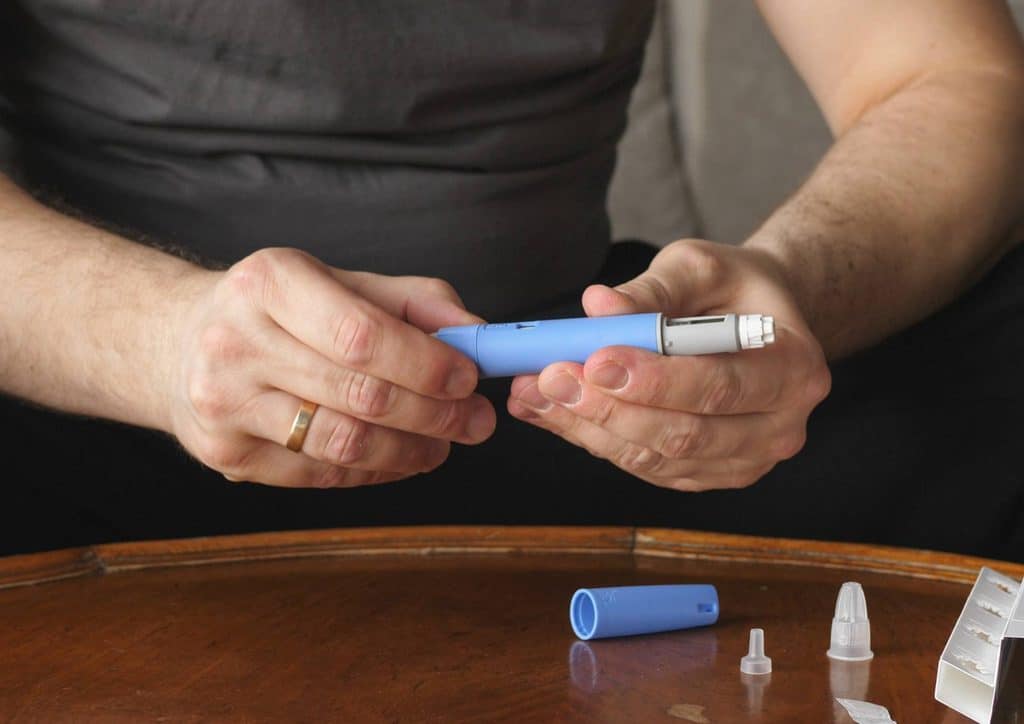 Natural Alternatives to Ozempic for Weight Loss 8 A man holds a blue and white electronic device, showcasing its design and features.