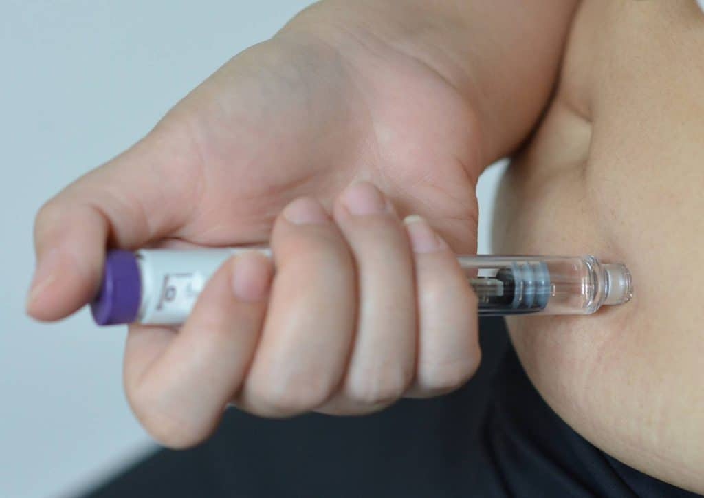 Natural Alternatives to Ozempic for Weight Loss 23 A person holding a small tube containing a needle, demonstrating a medical or laboratory procedure.