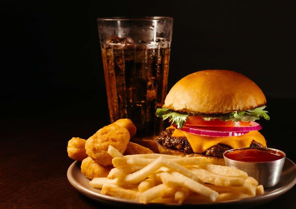 Natural Alternatives to Ozempic for Weight Loss 20 A plate with a hamburger and fries beside a glass of beer, showcasing a classic meal combination.