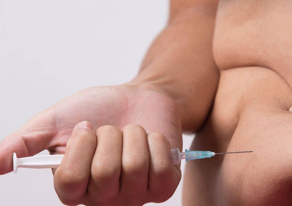 Natural Alternatives to Ozempic for Weight Loss 7 A man holds a syringe in his hand, preparing for a medical procedure or vaccination.