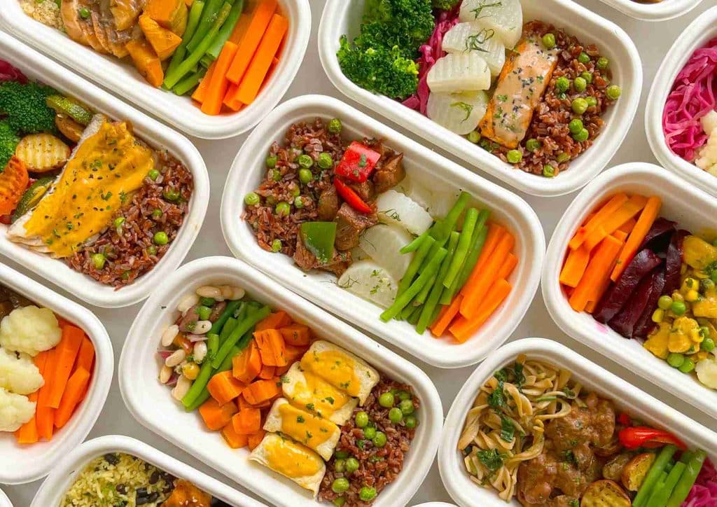How to Speed Up Your Metabolism (What Actually Works) 27 A collection of plastic containers filled with various types of food, showcasing a diverse assortment of meals and ingredients.