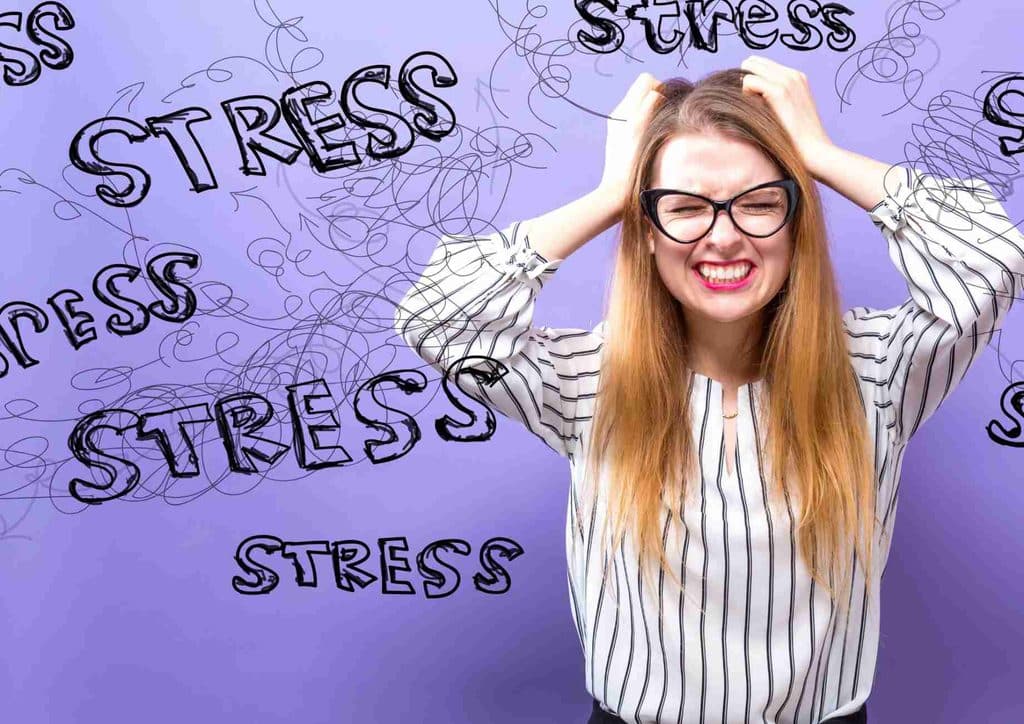 Why Am I Not Losing Weight? 8 Reasons a Nutritionist Sees Every Week 15 A woman holds her head in distress against a purple background featuring the repeated words "stress" and "stress."