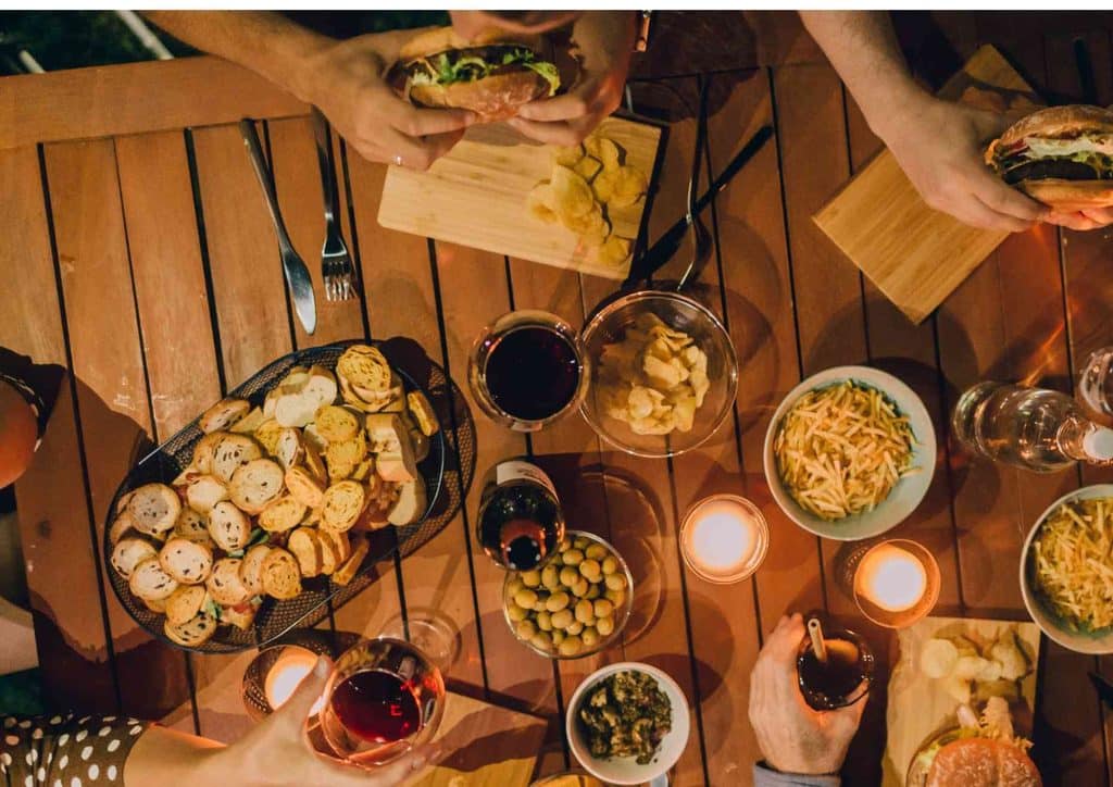 Why Am I Not Losing Weight? 8 Reasons a Nutritionist Sees Every Week 8 A diverse group of people enjoying a meal together at a table, sharing food and conversation in a warm atmosphere.