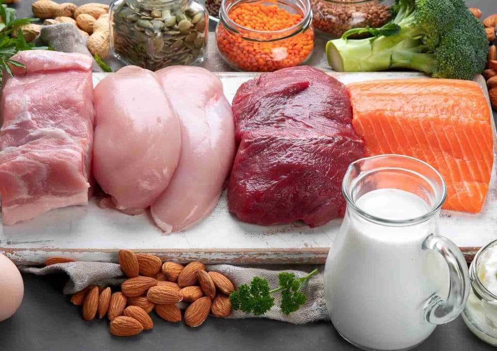 Why Am I Not Losing Weight? 8 Reasons a Nutritionist Sees Every Week 9 A variety of heart-healthy foods including fruits, vegetables, whole grains, nuts, and fish displayed on a wooden table.
