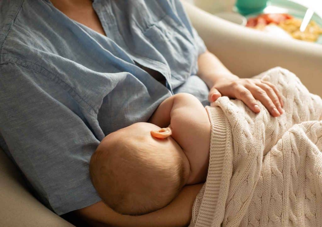 Losing Weight While Breastfeeding: What's Safe and Realistic 52 A woman gently cradles a baby in her arms, showcasing a tender moment of care and affection.