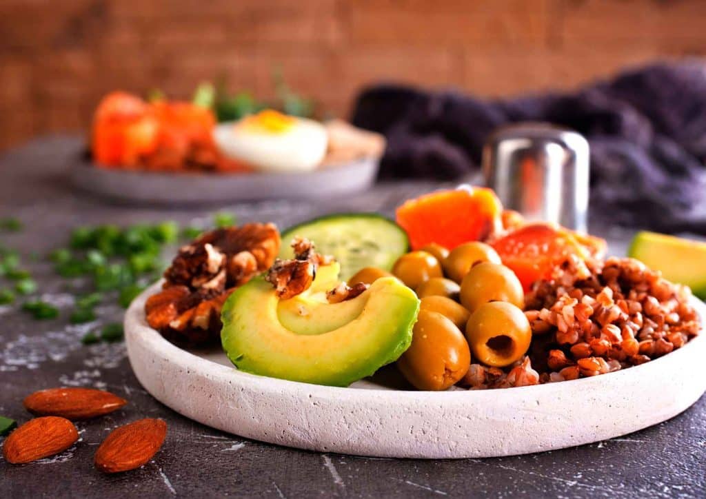 What Is a Balanced Diet for Weight Loss? 10 A vibrant bowl of food featuring avocado, olives, and assorted fresh ingredients, showcasing a healthy meal option.