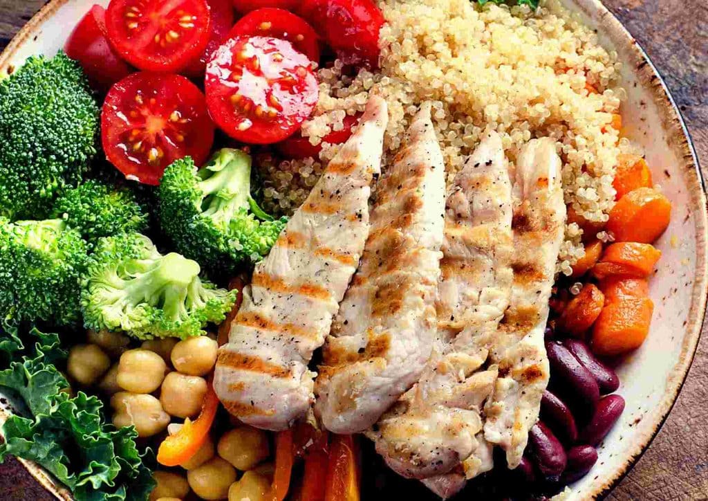 Healthy Dinners for Weight Loss: Easy Weeknight Ideas 1 A plate featuring grilled chicken, colorful vegetables, and a serving of rice, arranged appetisingly.