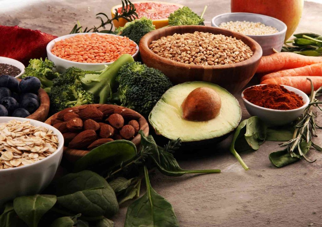 Vegetarian Diet for Weight Loss: How to Get It Right 11 An array of nutritious foods, including vibrant fruits, fresh vegetables, assorted nuts, and whole grains displayed together.