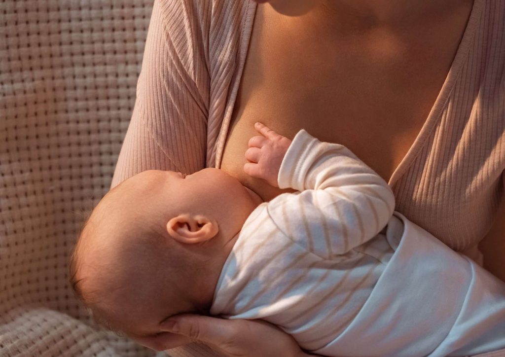 Losing Weight While Breastfeeding: What's Safe and Realistic 55 A woman gently breastfeeding her baby, showcasing a nurturing moment between mother and child.