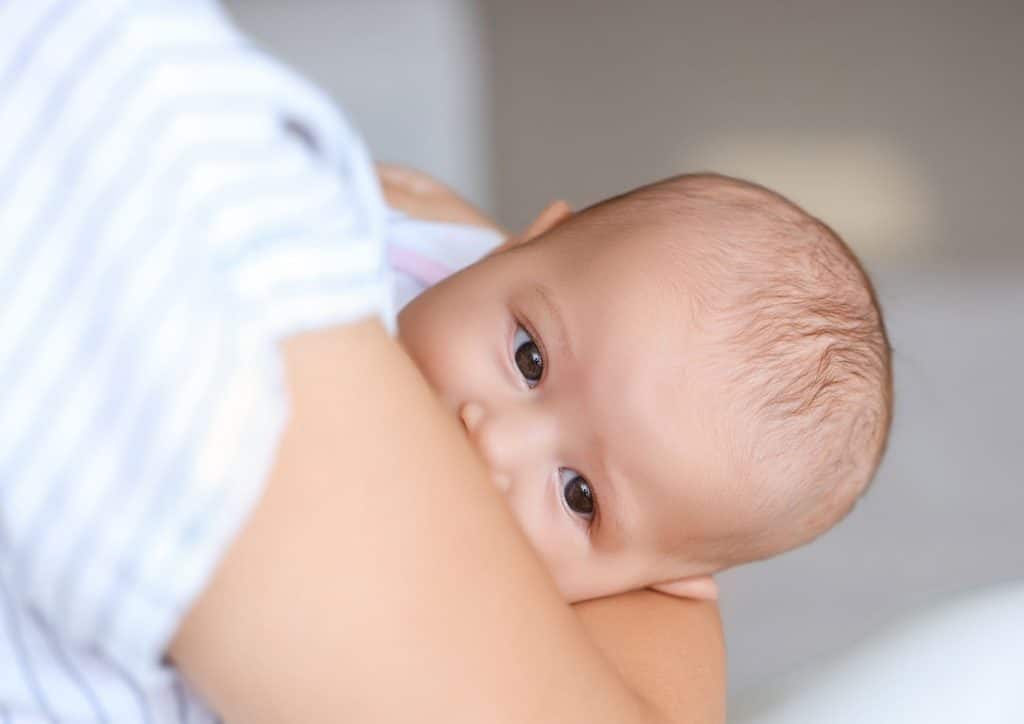 Losing Weight While Breastfeeding: What's Safe and Realistic 56 A woman gently cradles a baby in her arms, showcasing a tender moment of care and affection.