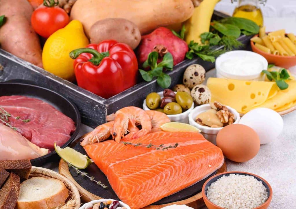 Is the Mediterranean Diet Good for Weight Loss? 6 A diverse spread of food featuring fish, assorted vegetables, eggs, and bread displayed together on a surface.