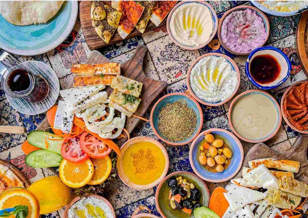 Is the Mediterranean Diet Good for Weight Loss? 8 A table filled with various dishes, including fruits, vegetables, meats, and desserts, showcasing a diverse spread of food.