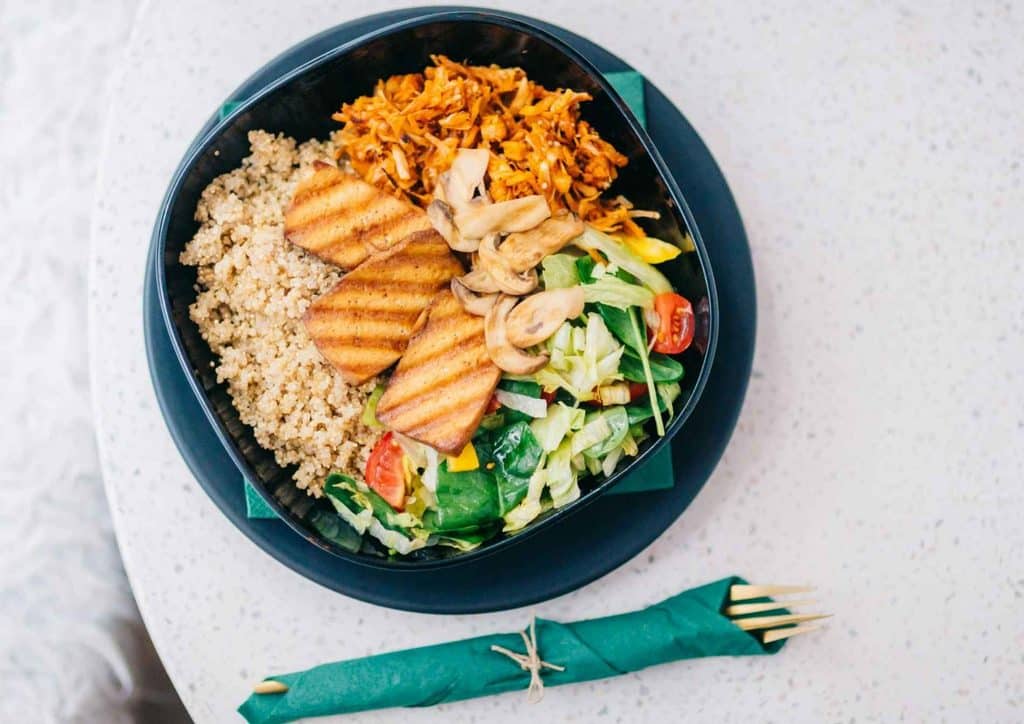 Healthy Dinners for Weight Loss: Easy Weeknight Ideas 6 A black bowl filled with a colourful salad, accompanied by a silver fork resting beside it.
