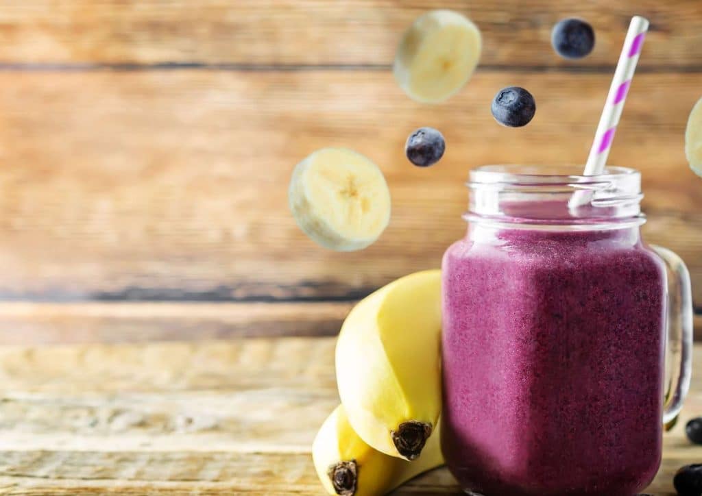 High Fibre Diet for Weight Loss: Why Fibre Keeps You Full 24 A blueberry smoothie with banana, garnished with fresh blueberries, placed on a rustic wooden table.