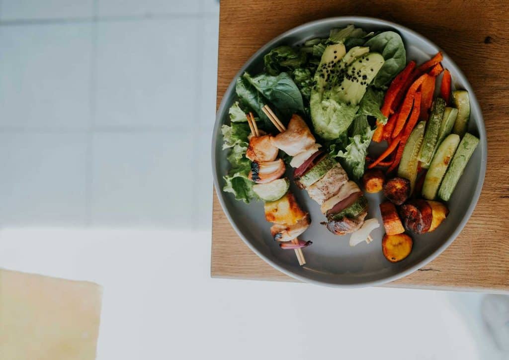 Healthy Dinners for Weight Loss: Easy Weeknight Ideas 7 A black bowl filled with a colorful salad, accompanied by a silver fork resting beside it.