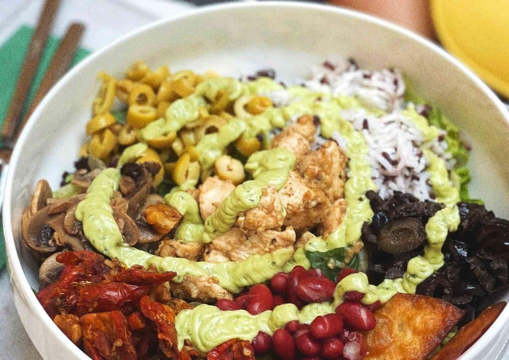 Healthy Dinners for Weight Loss: Easy Weeknight Ideas 21 A bowl filled with rice, sliced avocado, and assorted colourful vegetables, arranged attractively.