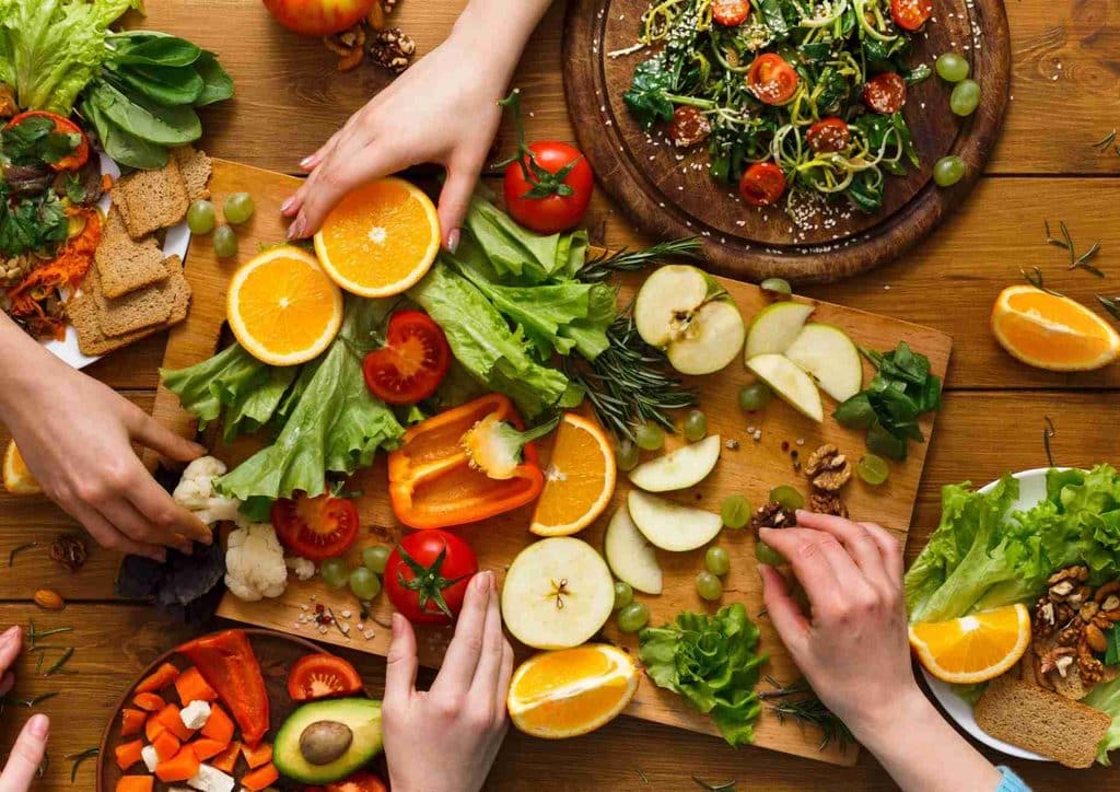 Healthy Dinners for Weight Loss: Easy Weeknight Ideas 22 A diverse group of people enjoying a meal of healthy food at a dining table, smiling and engaging in conversation.