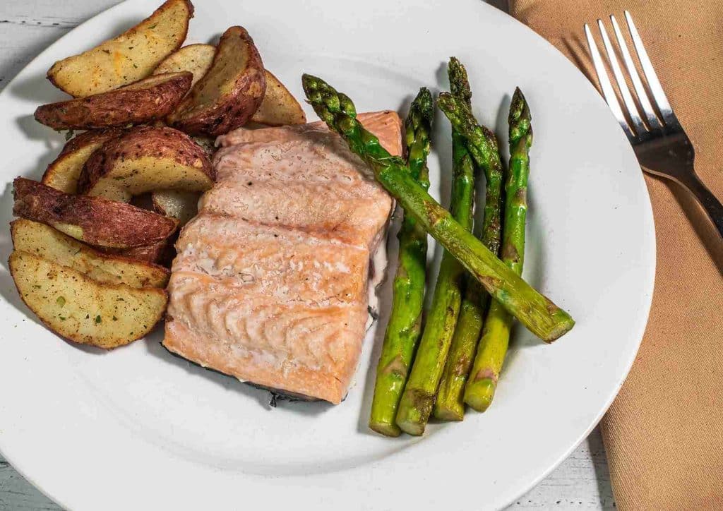 Healthy Dinners for Weight Loss: Easy Weeknight Ideas 16 A plate featuring grilled salmon, roasted potatoes, and steamed asparagus arranged artfully.