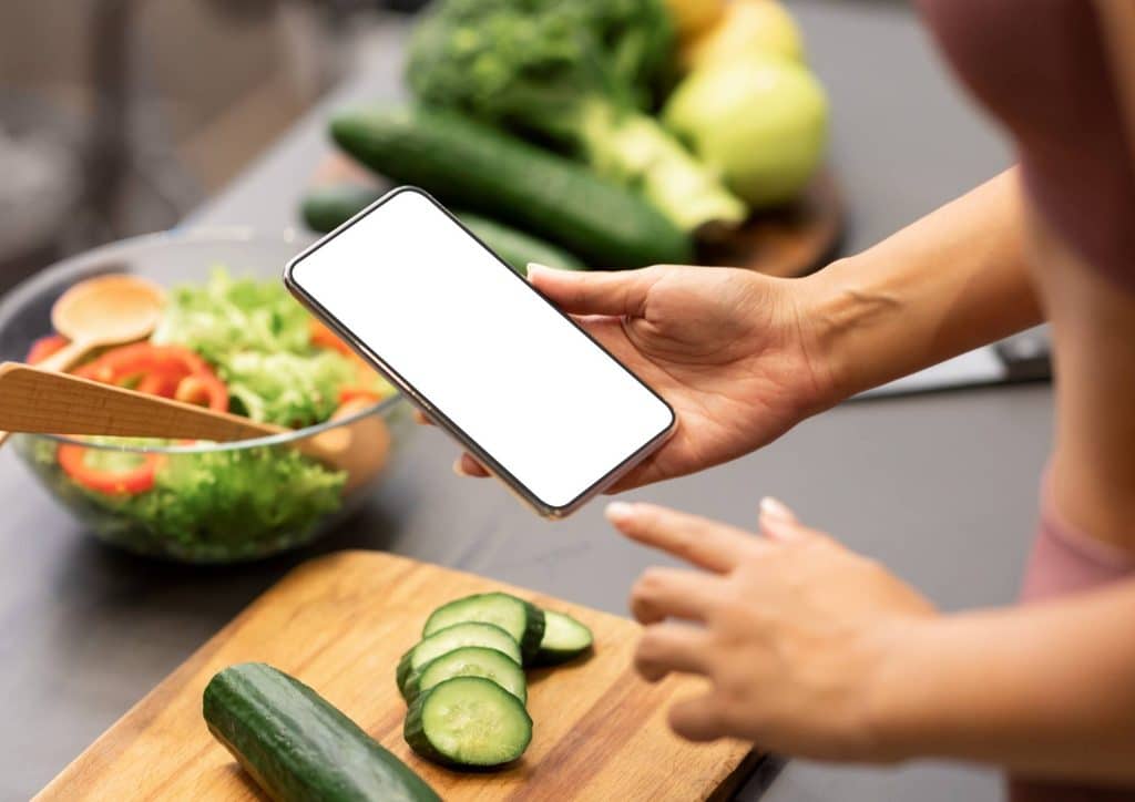 Healthy Dinners for Weight Loss: Easy Weeknight Ideas 20 A woman holds a smartphone with a blank screen, looking thoughtfully at the device.