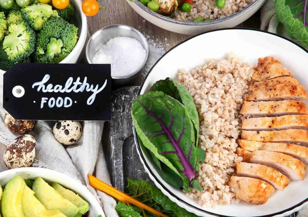 Healthy Dinners for Weight Loss: Easy Weeknight Ideas 23 A plate filled with colorful vegetables and grains, accompanied by a sign reading "Healthy Food".