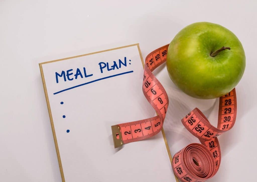 Healthy Meal Plans for Weight Loss: How to Build One That Lasts 13 A meal plan featuring an apple and a measuring tape, representing nutrition and dietary management for health.