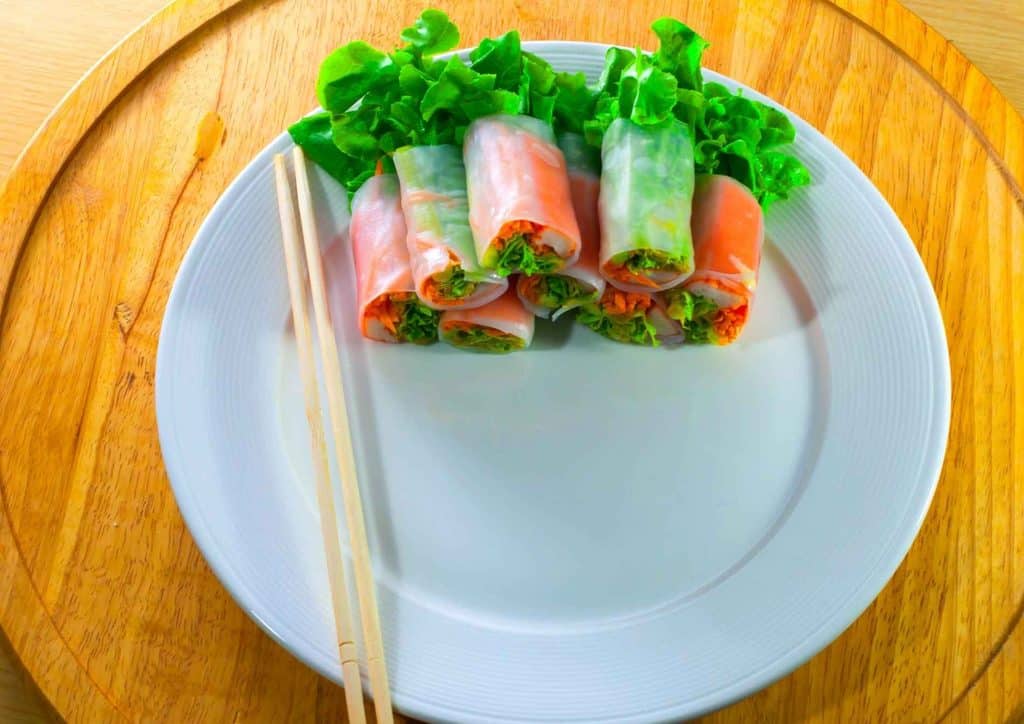 Healthy Dinners for Weight Loss: Easy Weeknight Ideas 28 A plate of Asian spring rolls accompanied by chopsticks, showcasing a delicious appetizer ready to be enjoyed.