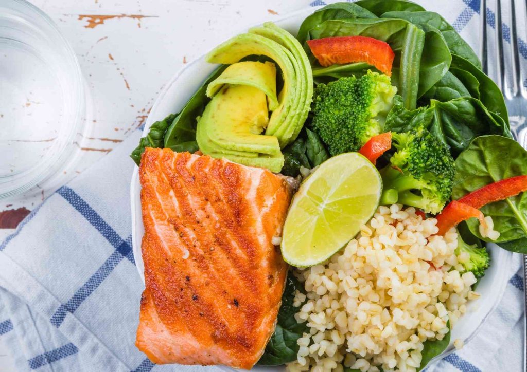 Healthy Lunches for Weight Loss: Work and Home Ideas 42 A plate featuring grilled salmon, steamed rice, broccoli florets, and sliced avocado arranged artfully.