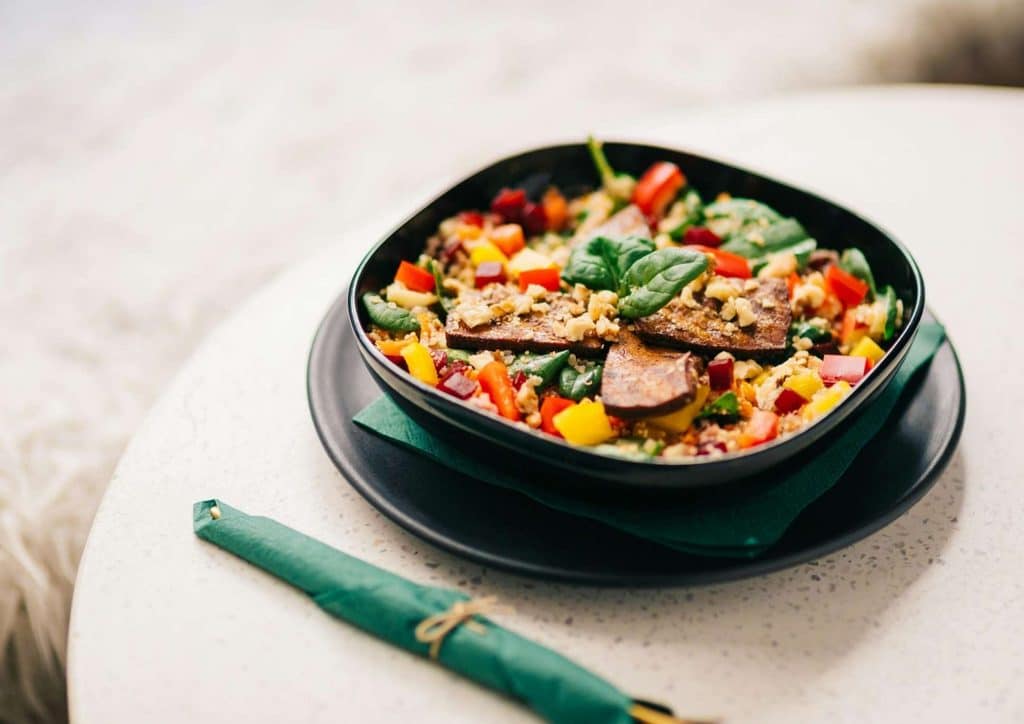 Healthy Lunches for Weight Loss: Work and Home Ideas 41 A bowl of salad featuring mixed vegetables and meat, placed on a wooden table.