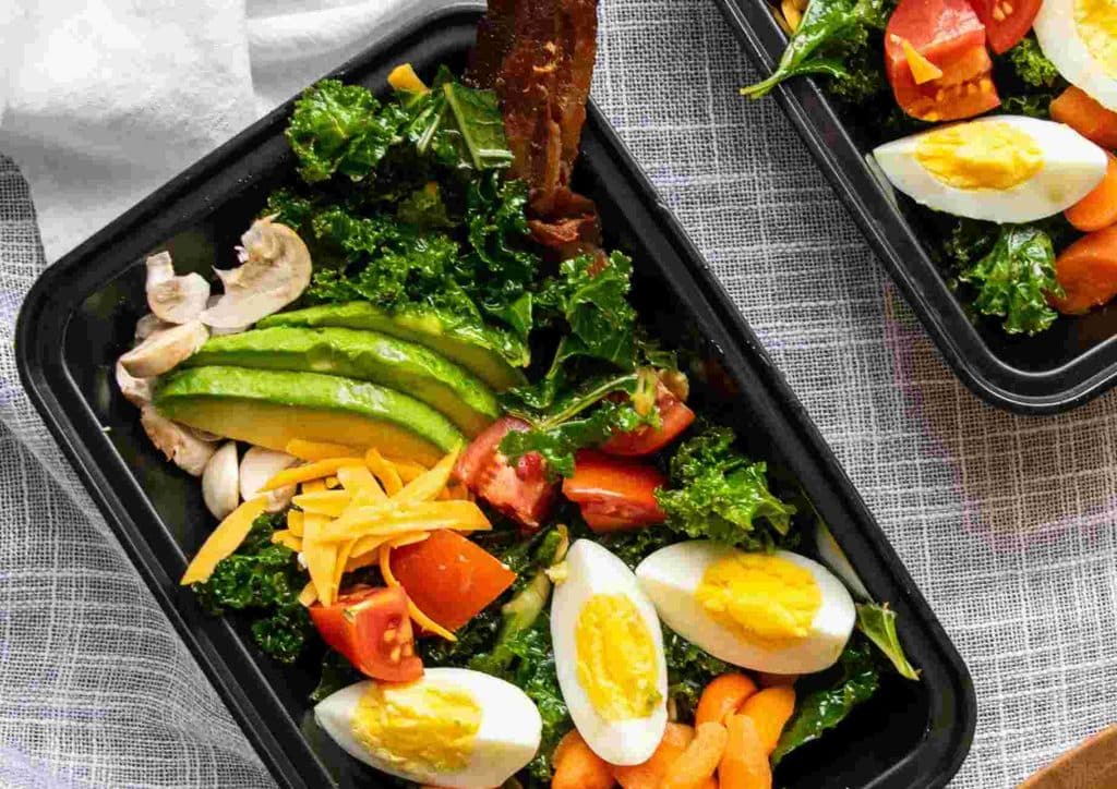 Healthy Lunches for Weight Loss: Work and Home Ideas 40 Two black plastic containers filled with different types of food, placed side by side on a flat surface.