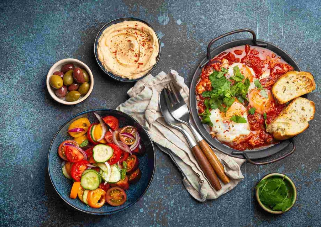 Healthy Lunches for Weight Loss: Work and Home Ideas 39 A diverse spread of food items is displayed on a table, featuring appetizers, entrees, and desserts in vibrant colours.