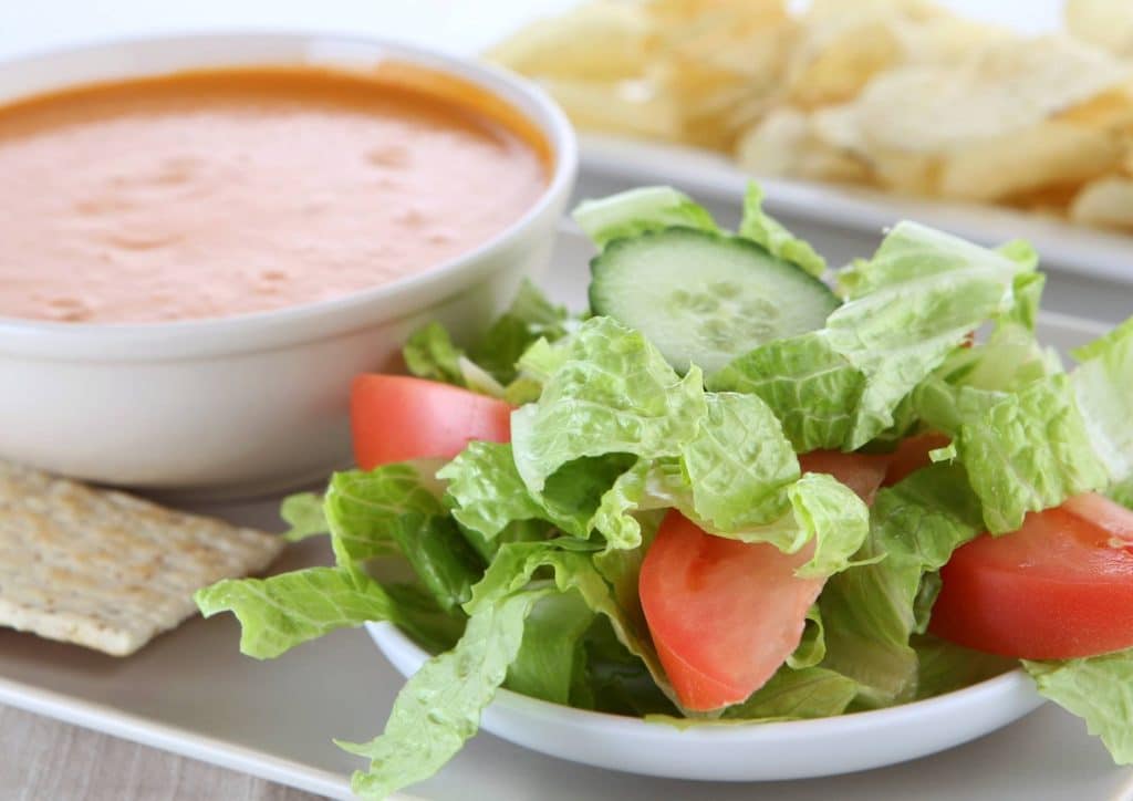 Healthy Lunches for Weight Loss: Work and Home Ideas 37 A plate featuring a fresh salad, crispy chips, and a bowl of steaming soup.