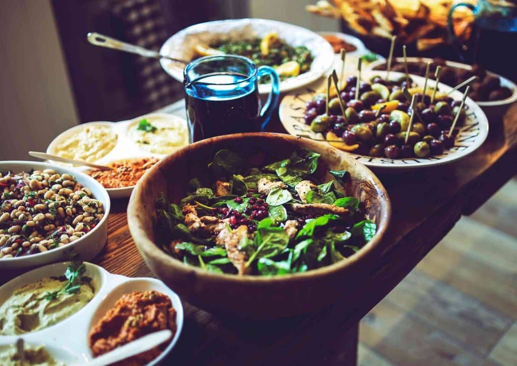 Healthy Lunches for Weight Loss: Work and Home Ideas 48 A table filled with various dishes, including fruits, vegetables, meats, and desserts, showcasing a diverse spread of food.