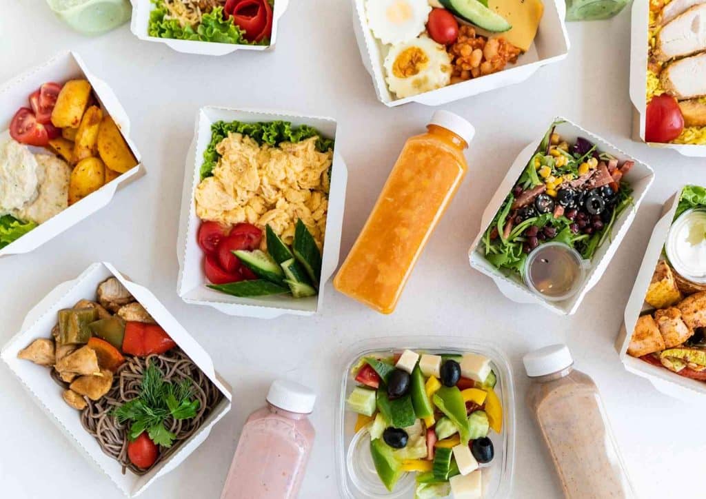 Healthy Lunches for Weight Loss: Work and Home Ideas 46 An assortment of dishes in white containers, featuring a mix of vibrant foods and ingredients.