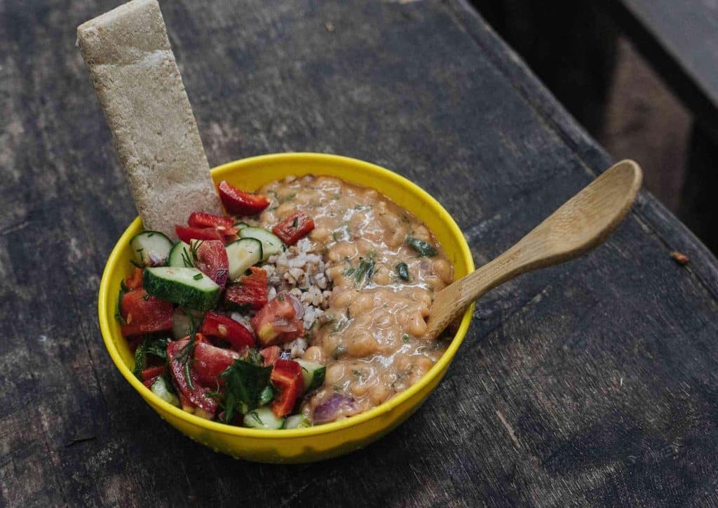 Healthy Lunches for Weight Loss: Work and Home Ideas 45 A bowl of food accompanied by a spoon and a sliced cucumber on the side.