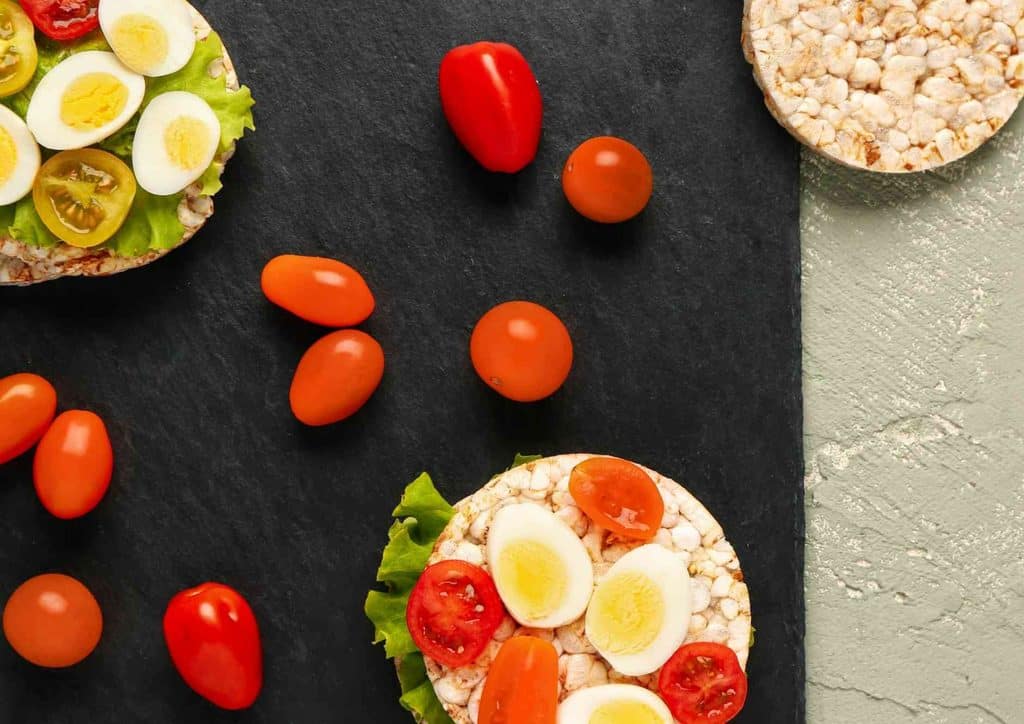 Easy Meals for Weight Loss When You're Short on Time 43 A healthy sandwich featuring eggs, tomatoes, and assorted vegetables displayed on a black slate surface.