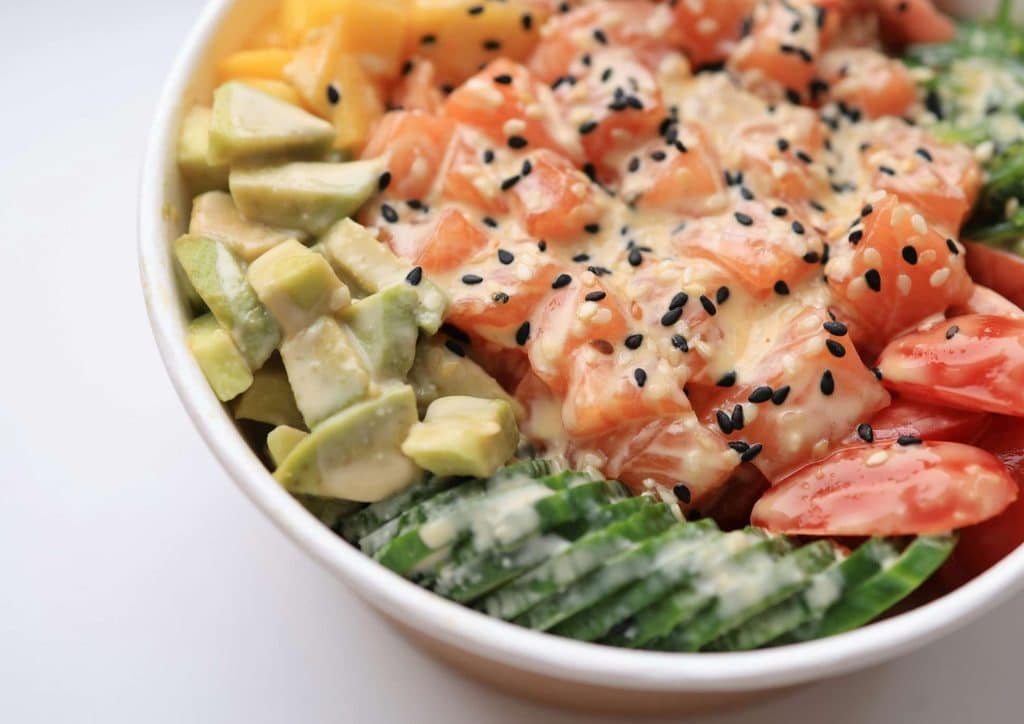 Easy Meals for Weight Loss When You're Short on Time 38 A bowl filled with sliced avocado, cherry tomatoes, and pieces of salmon, arranged attractively for a healthy meal.