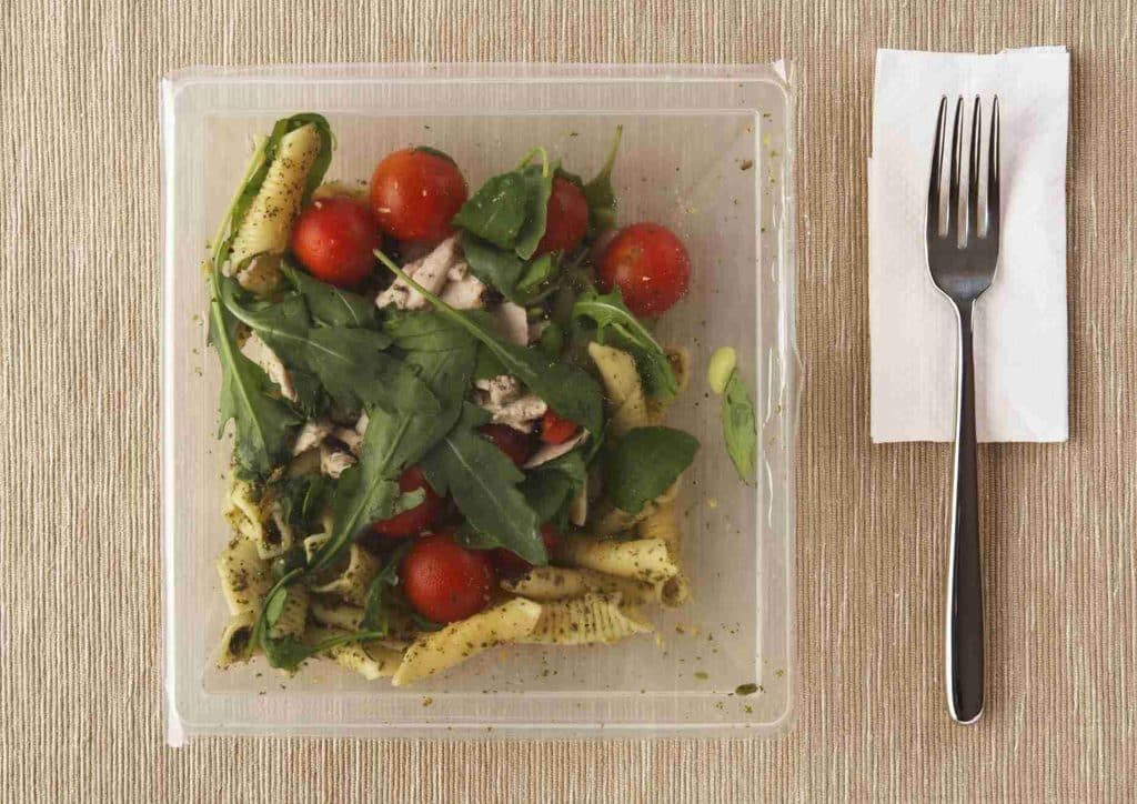Easy Meals for Weight Loss When You're Short on Time 37 A plastic container filled with a fresh salad, accompanied by a fork resting on the side.