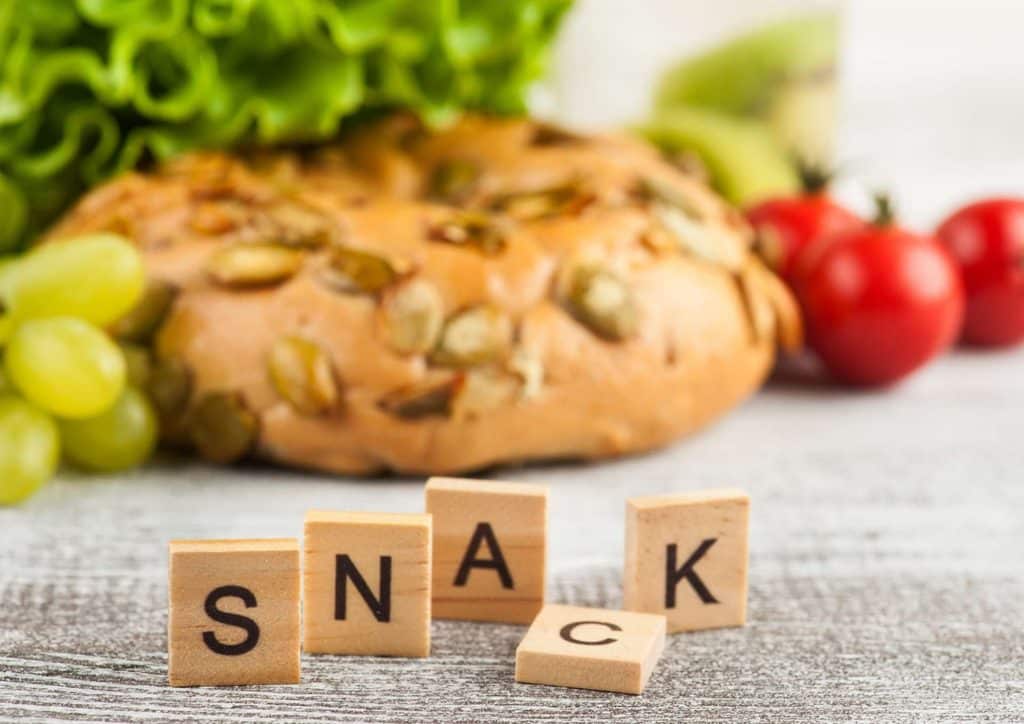 Healthy Snacks for Weight Loss That Actually Keep You Full 1 A variety of nutritious snacks displayed, featuring sliced fruits, mixed nuts, and fresh vegetables on a rustic table.