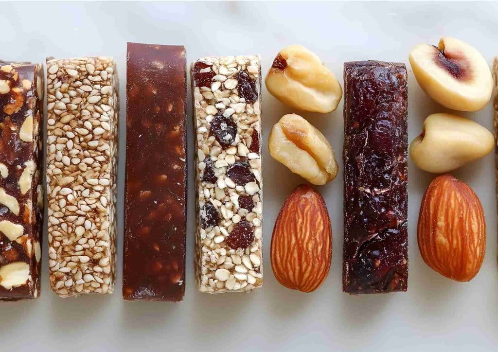 Healthy Snacks for Weight Loss That Actually Keep You Full 13 A diverse selection of nuts and dried fruits displayed in a row, showcasing various textures and colours.