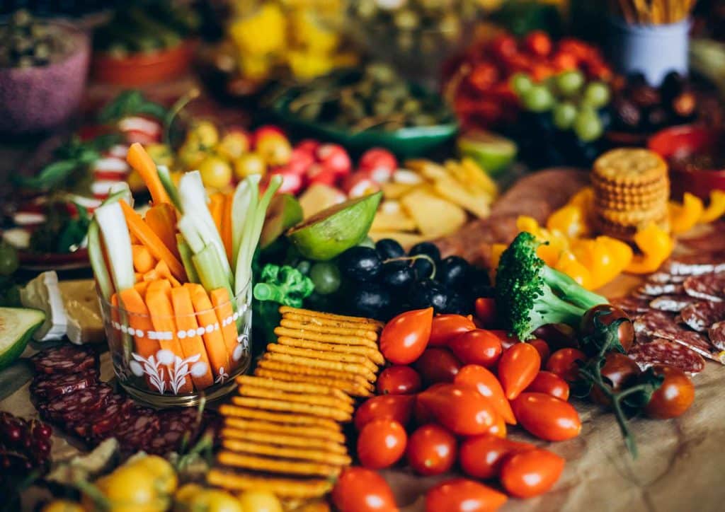 Healthy Snacks for Weight Loss That Actually Keep You Full 10 A table displaying an assortment of dishes, including fruits, vegetables, and main courses, arranged for a meal.